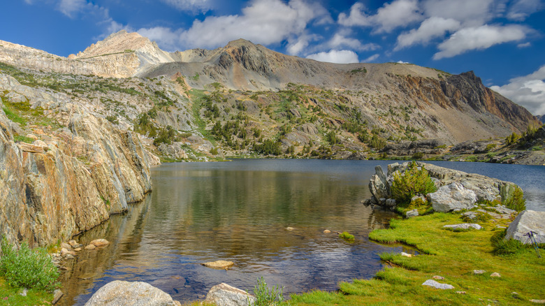 Steelhead Lake with mountains and a grass field framing it in California.