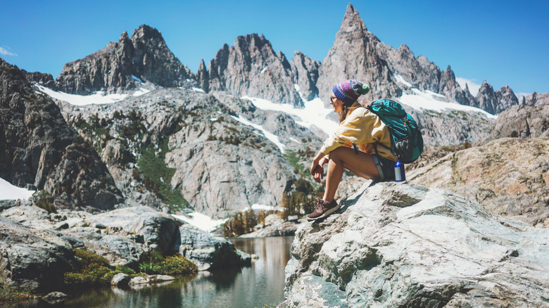 A backpacker sits on a rock near Minaret Lake in the High Sierra