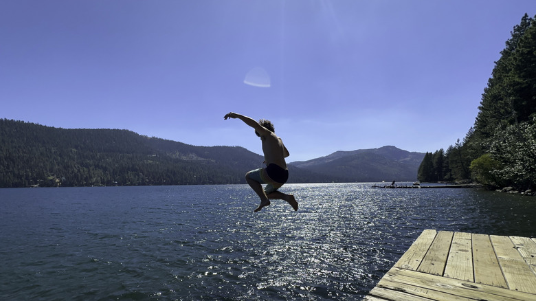 Teen jumping off a pier into Donner Lake in Tahoe National Forest