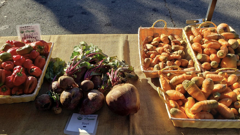 Carrots, peppers, and beets displayed on a table at Windsor Certified Farmers Market, California.