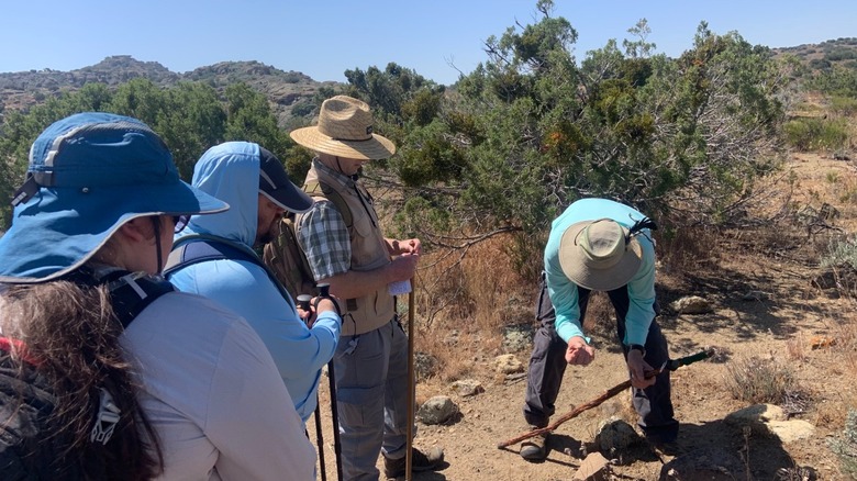 Hikers wearing sun protection stop along the trail at Tomo-Kahni State Historic Park