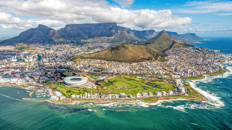 Aerial photo of Cape Town with ocean in front and mountains in back.