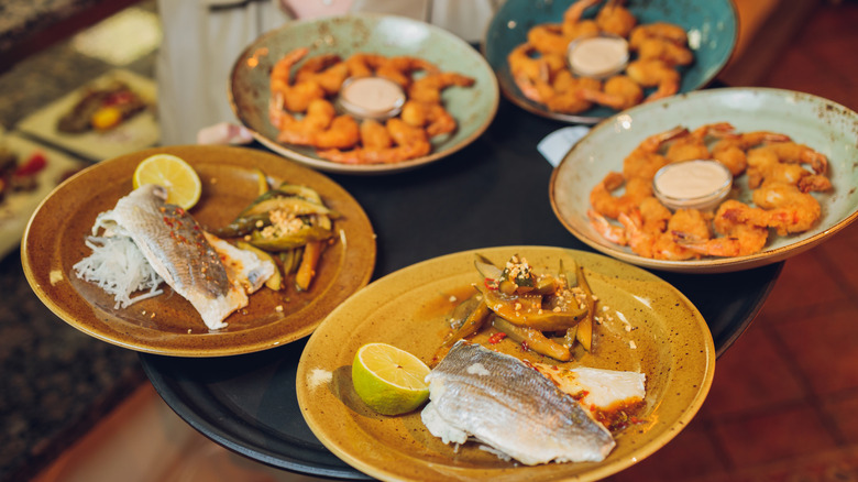 Waitress carries tray of fresh seafood on plates