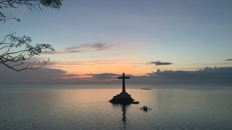 The above-water cross marking Camiguin's Sunken Cemetery at sunset