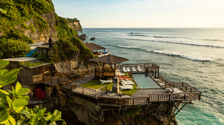 Aerial view of a private clifftop villa overlooking the Indian Ocean in Uluwatu, Bali, Indonesia, with a gazebo, sun loungers, and a plunge pool visible