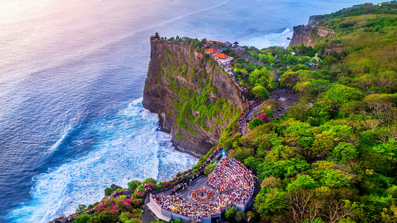 Aerial view of the sacred Uluwatu Temple overlooking the waters of the Indian Ocean and featuring the amphitheater where the traditional kecak dance is performed, photographed at sunset