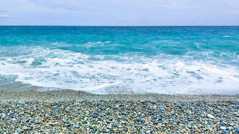 Waves crashing on the pebble-lined shores of Mabua Pebble Beach outside of Surigao City, Philippines