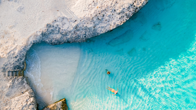 Overhead view of a white sand cove in Tres Trapi beach with crystal clear water in Aruba