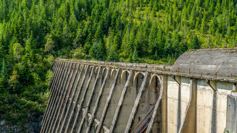 An abandoned structure of a hydroelectric dam against mountains