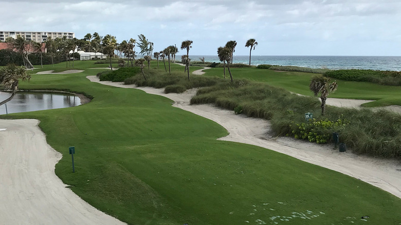 wide view of golf course with sandy banks next to ocean