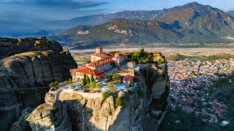Monastery on top of craggy rock formation with village down below
