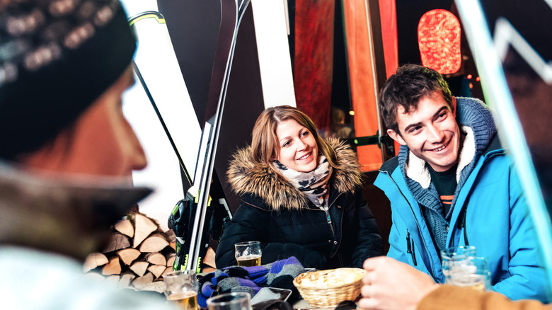 People drinking beer and eating chips at apres ski outdoors