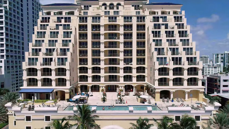 Tall, ivory-colored hotel building with elevated pool deck.