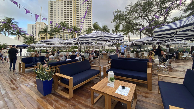 Striped umbrellas and outdoor seating at The Wharf Fort Lauderdale