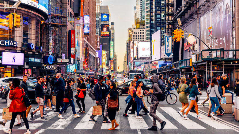 People walking across a busy New York street