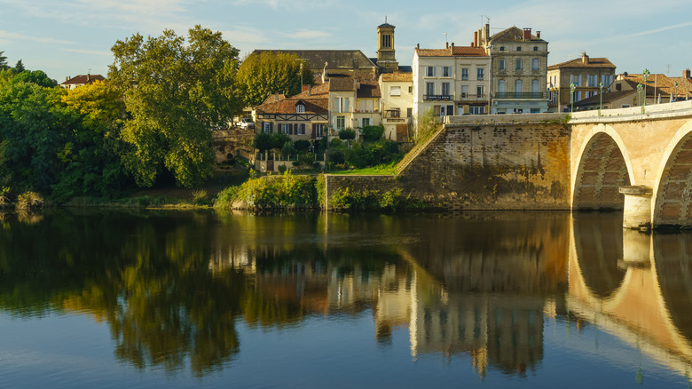 Old bridge over a river with buildings reflected in the water