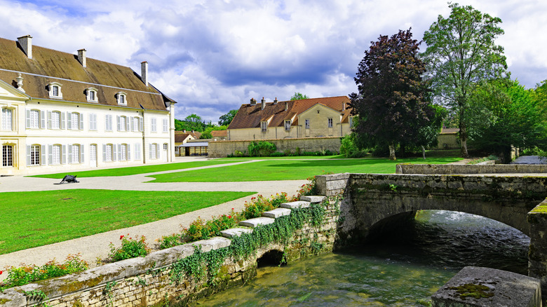 Grounds of the Auberive Abbey with a bridge and stream, located in Forêts National Park in France
