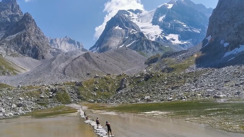 Crossing the stone bridge on the Lac des Vaches hike in Vanoise National Park, France.
