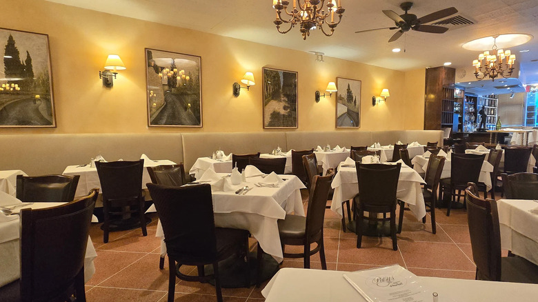 Empty tables with white tablecloths inside Patsy's