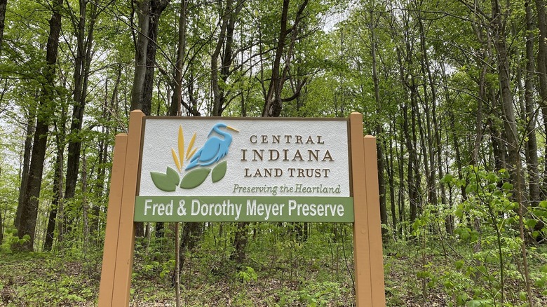 Signage marking preserve trailhead surrounded by tall beech trees