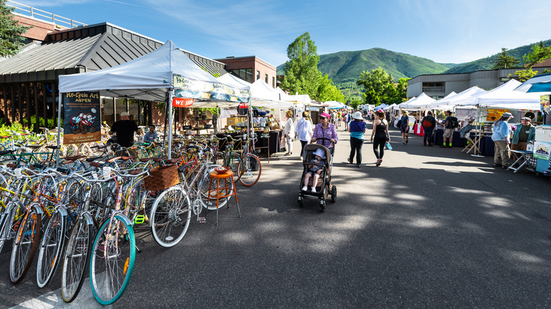 Vendors in a street with dozens of bikes and people