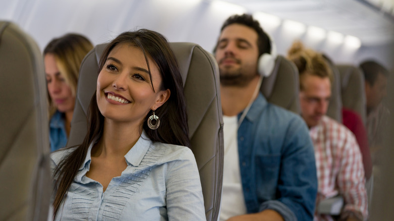 Smiling woman in aisle plane seat
