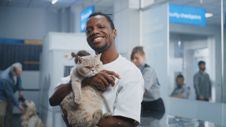 A man holding his cat at airport security