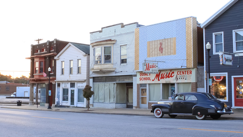 Vintage car on road in front of storefronts in Quincy, IL.