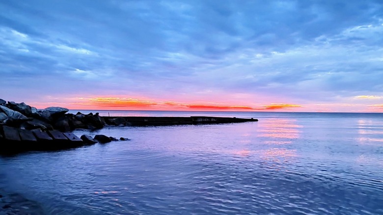 The sunrise over the blue lake with a blue sky full of whispy clouds at Geneva State Lake