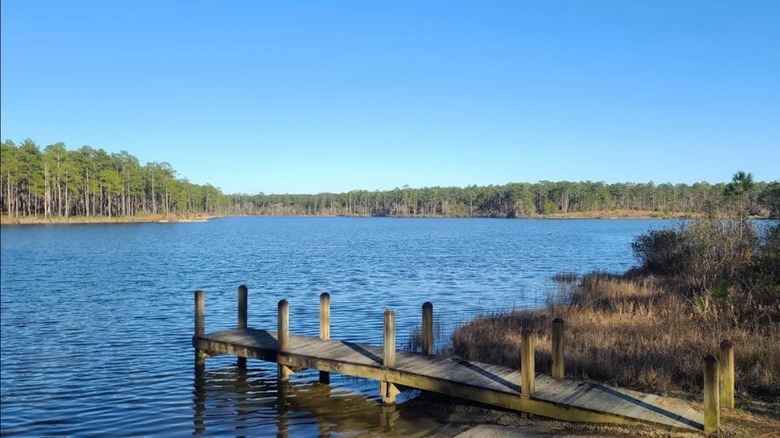 Bright blue Geneva State Lake with a rustic dock on it and a blue, cloudless sky above