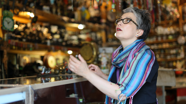 Woman glancing upward in a antique shop