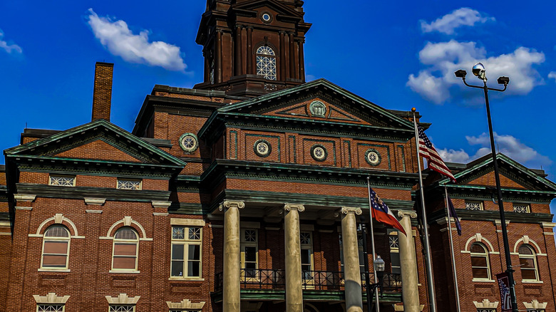 Newnan, Georgia public historic courthouse in town square, entrance facade view with blue sky in background