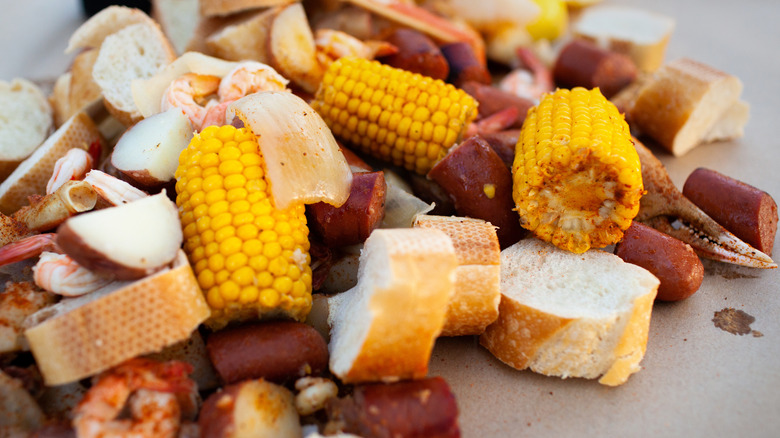 A Lowcountry seafood boil with corn, bread, potatoes, and seafood