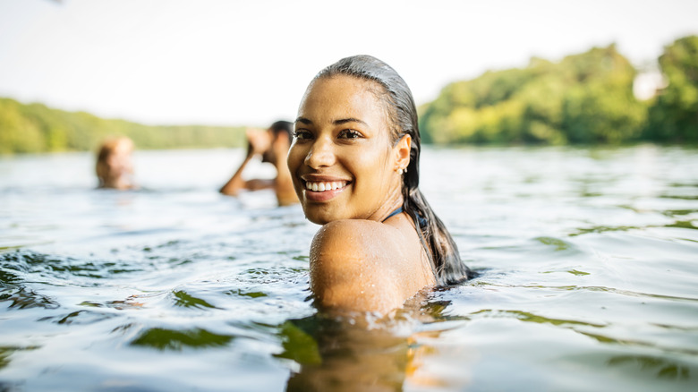 three people swimming in a lake