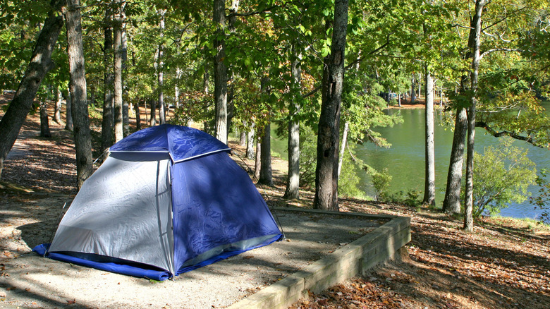 A blue tent by a lake