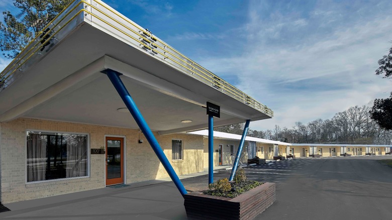 The original entrance to the New South Motor Inn with neon lights and parking space