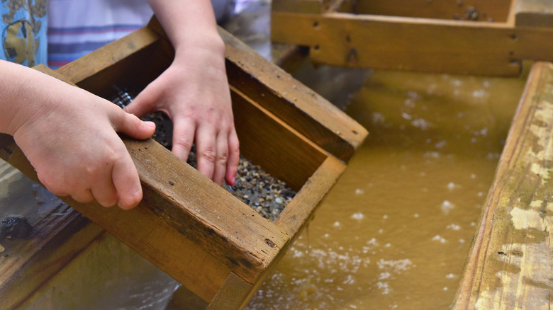 A child's hands close up, participating in a gem mining activity