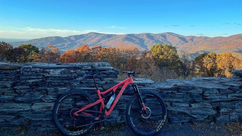View of a bike and fall foliage mountains in the background from the top of Pinhoti 3 trail near Mulberry Gap Basecamp