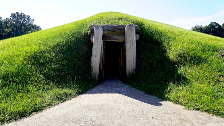 The entrance of a burial mound at the Ocmulgee Mounds National Historical Park outlined by a roughly hewn, wooden doorway