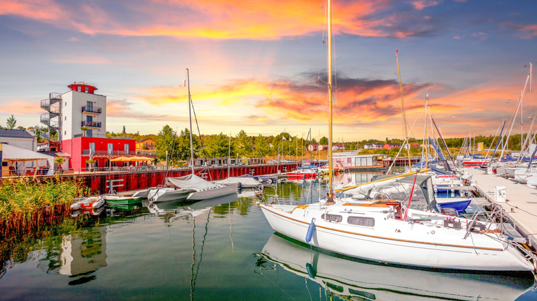 Sailboats are moored at a marina in Lake Geiseltal during a sunset in Germany