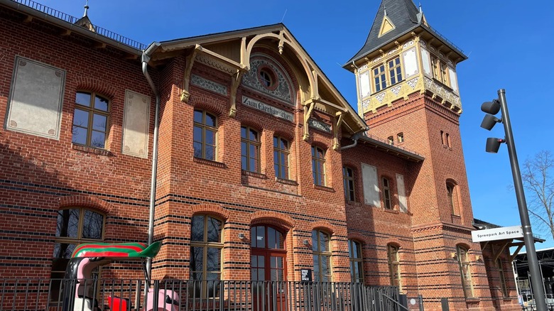Brick facades of a 19th-century two story building and tower against blue sky's