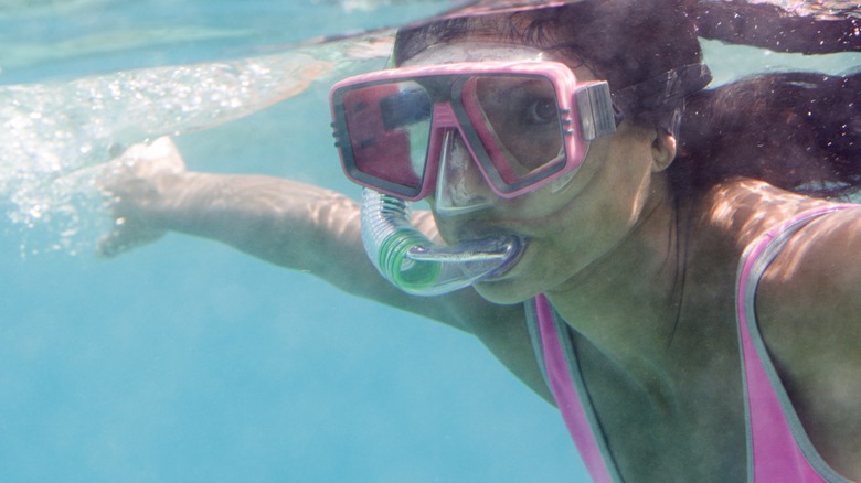 Woman snorkels just below surface