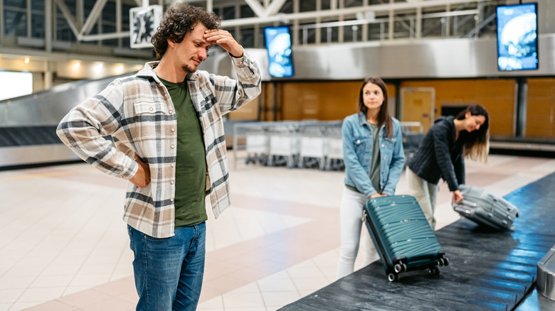 A man waiting for his luggage at the carousel