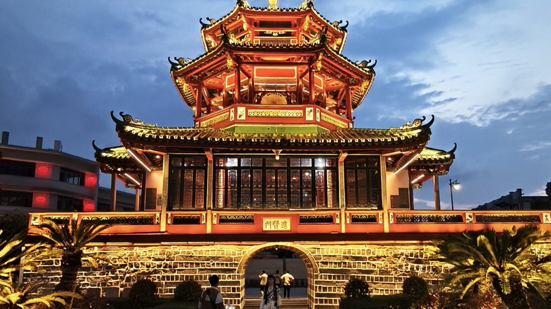 Chinese temple Jinxian Gate Tower lit up with lights against the dusk sky