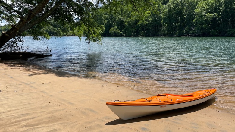 Orange and white kayak on the sandy shore at Mountain Island Lake, North Carolina