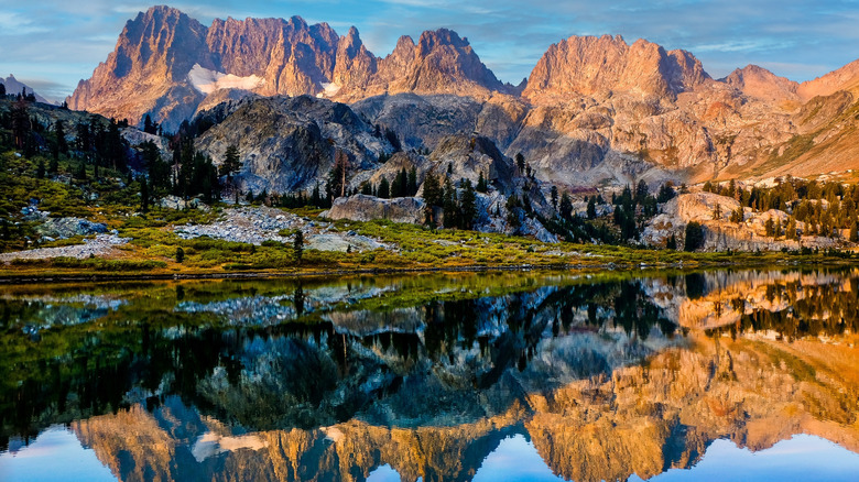 Ediza Lake with jagged granite peaks in the background reflected in the water and snow dusted on the landscape
