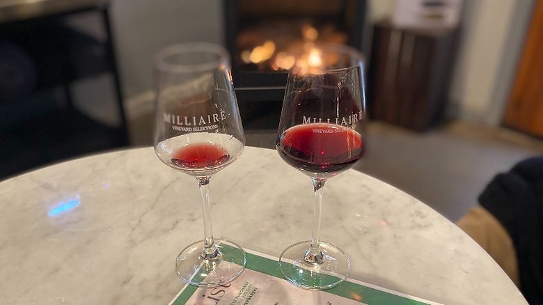 Two glasses of red wine in glasses beside a fireplace at Milliaire Winery in Calaveras County.