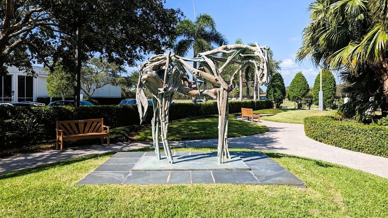 A sculpture of a horse made from driftwood on a manicured lawn at Vero Beach Museum of Art, Florida