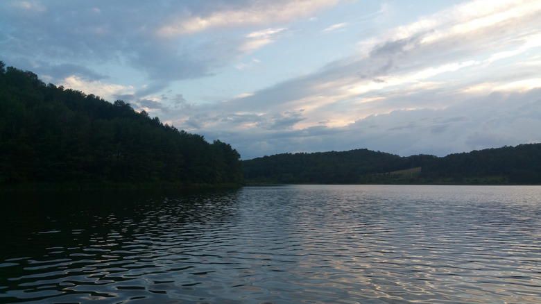 Pensylvania's Beechwood Lake, with water surrounded by treed hills under a cloudy blue sky