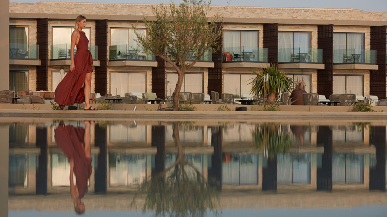 Woman in a red dress walks by suites at King Jason Zante